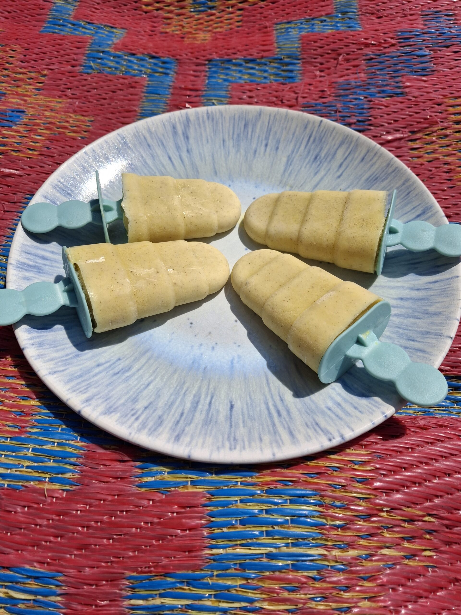 Selbstgemachtes, gesundes Eis am Stiel mit Mango und griechischem Joghurt auf Teller