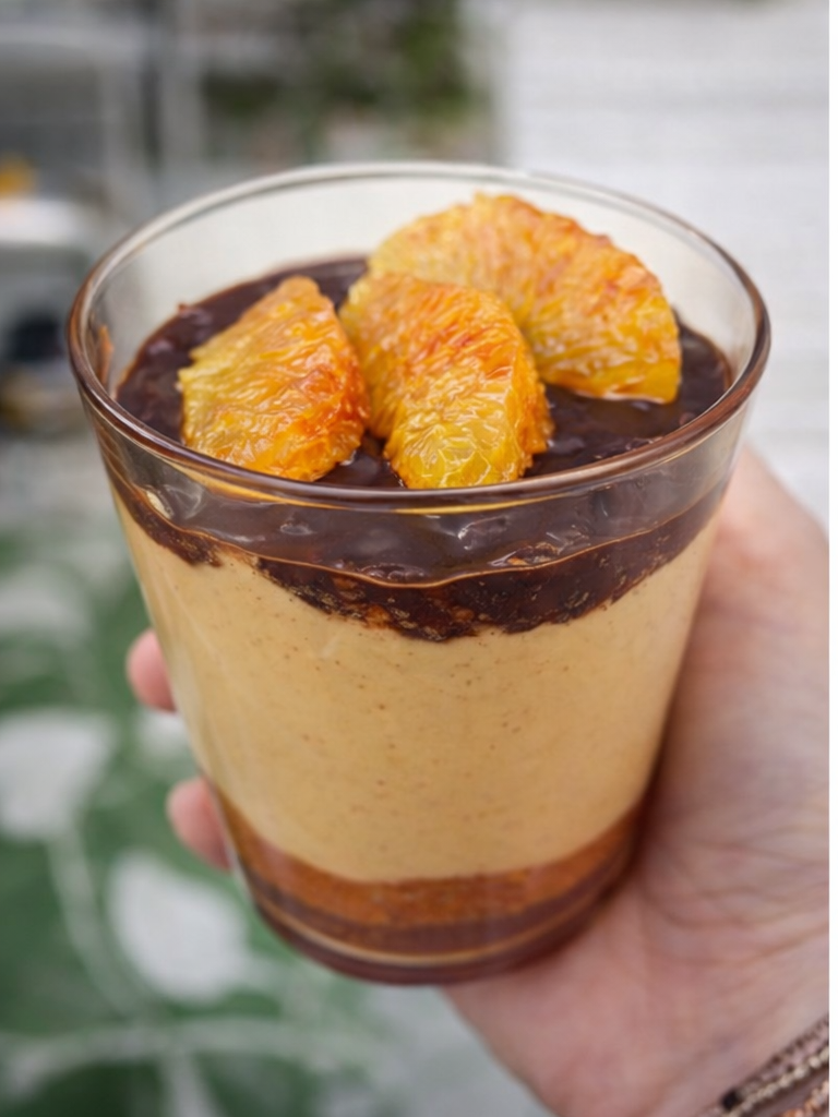 Proteinreiches Dessert im Glas mit Orange, Haselnüssen und dunkler Schokolade